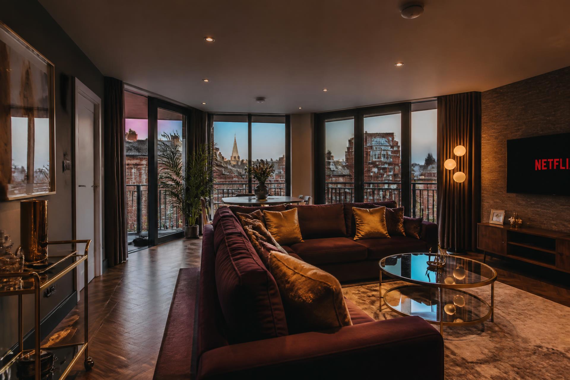 Styled short-let apartment living room overlooking Chester rooftops at dusk